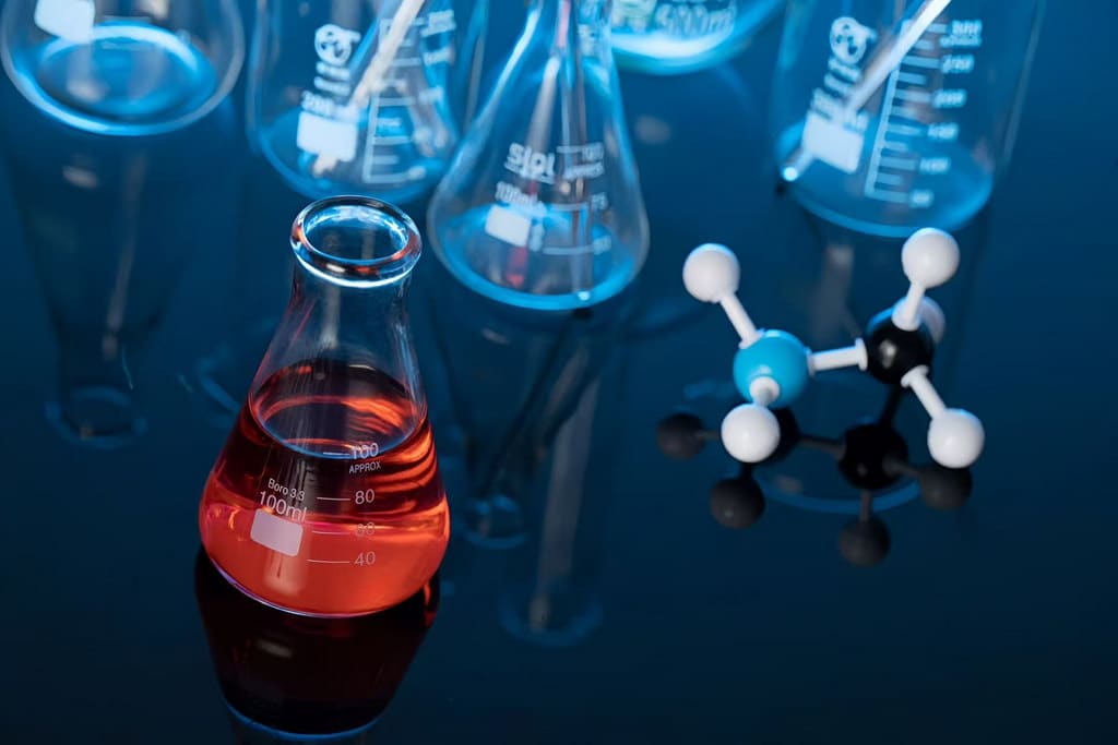 Laboratory glassware and molecular models for ZXCHEM Glyoxal insights (CAS 107-22-2)